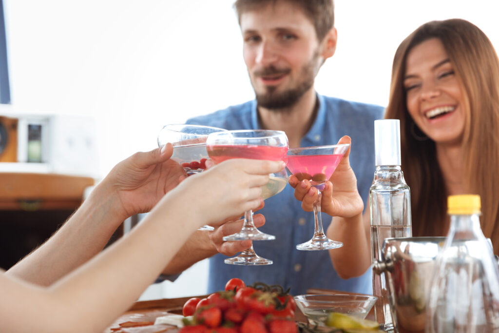 Close Up Of Couple At Party Making A Toast With Drinks Together